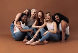 Portrait of six laughing women of different ages and body types sitting together