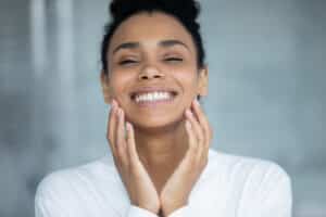 Happy black woman feels rejuvenated in her skin after microneedling