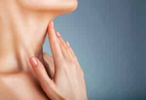 Woman holds her neck, unsure whether signs of aging are worthy of having surgery