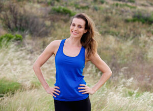 Woman in blue workout attire looks great after two kids and a mommy makeover.
